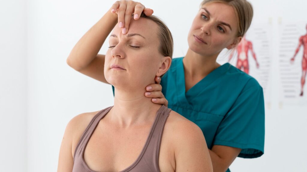 Facial Muscle Rehabilitation Therapy in Thrissur showing a therapist gently performing facial and neck muscle assessment on a female patient in a clinical setting